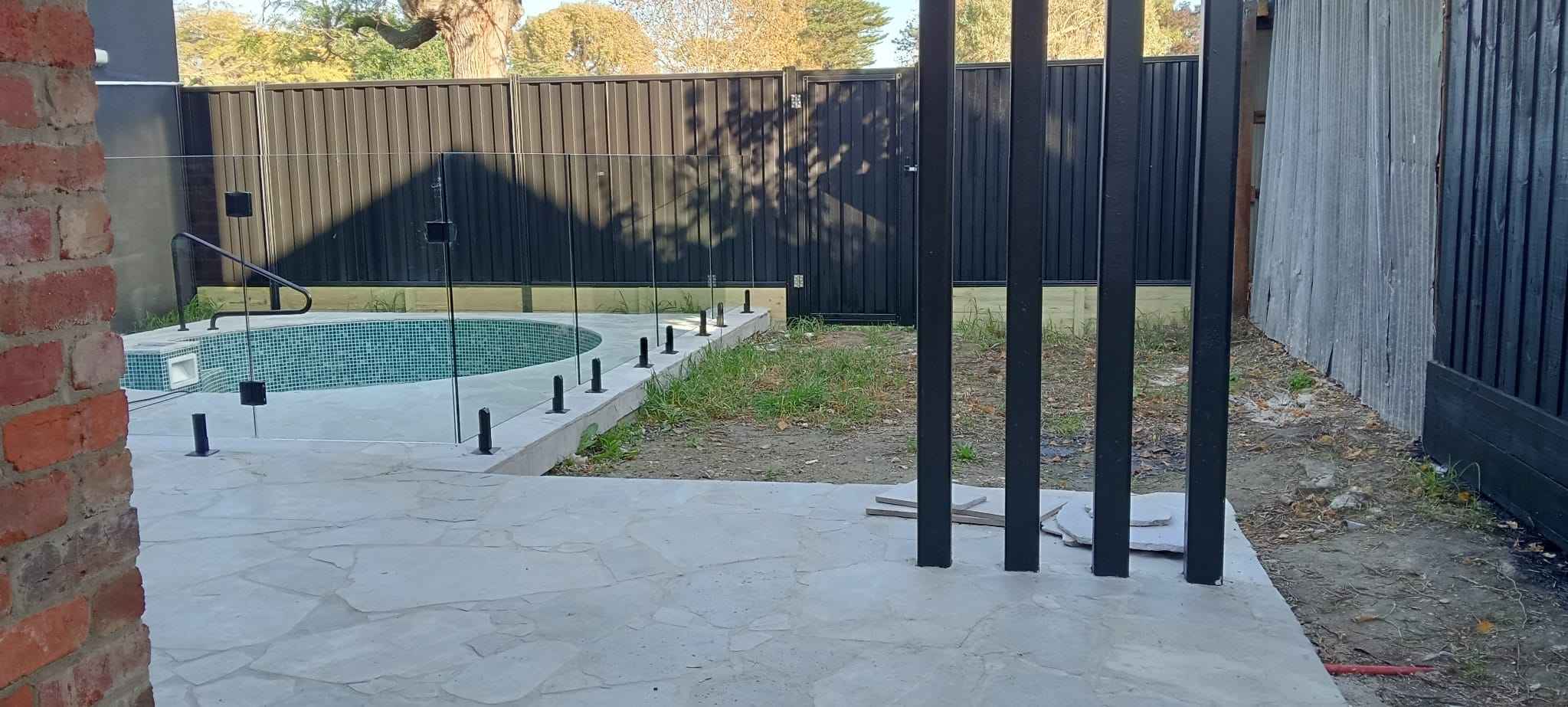 Glass pool fence with black aluminium feature posts